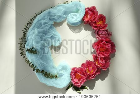 Composition of gauzy fabric and tulips on light background