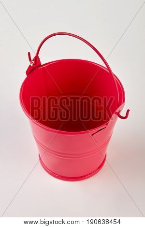 Single empty metal bucket isolated. Red metal decorative bucket on white background.