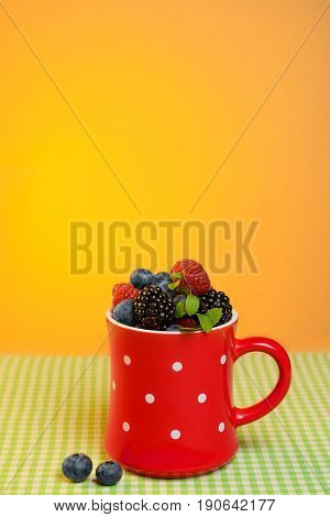 Cup with scuttered berries on the table