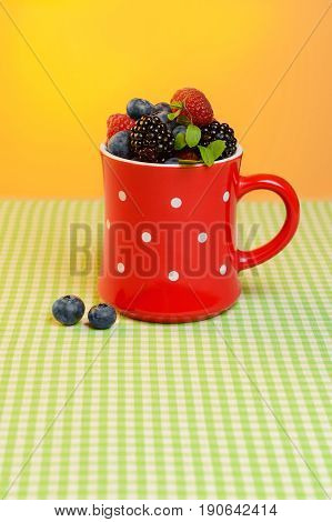Cup with scuttered berries on the table