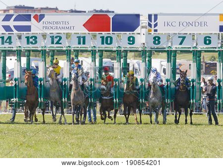 STOCKHOLM SWEDEN - JUNE 06 2017: Start of the gallop race for arabian race horses and colorful jockeys at Nationaldags Galoppen at Gardet. June 6 2017 in Stockholm Sweden