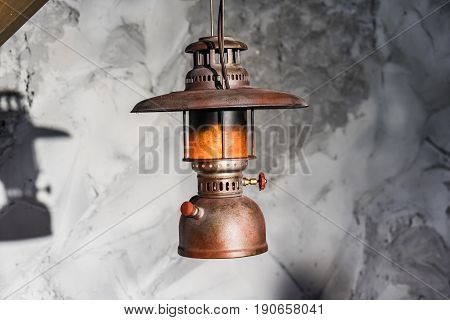 Vintage kerosene oil Lantern lamp burning with a soft glow light and antique rustic stone wall