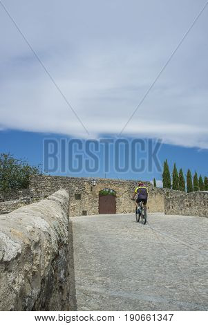 Biker climbing the medieval Castle of Trujillo Spain. Old town