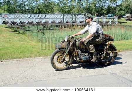 WROCLAW POLAND - JUNE 3: Reconstruction groups rally. Militarians fan gathering people in uniforms historical vehicles and weapons. Man driving German motorcycle from World War II on June 3rd 2017 in Wroclaw.