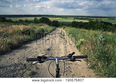 First person view on a sport bicycle before descending into the landscape valley