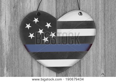 Retro USA thin blue line flag on a heart shape wood sign on weathered wood