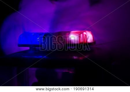 Red Light Flasher Atop Of A Police Car. City Lights On The Background. Police Government Concept