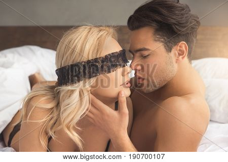 Young couple man and woman intimate relationship on bed kissing