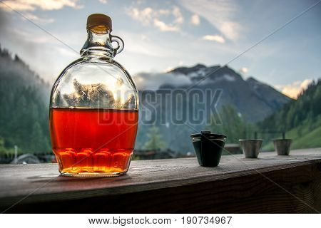 Drinking plum brandy after a long hiking tour in the mountains in Austria during sunset