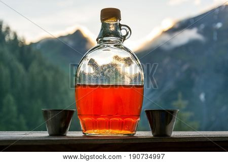 Drinking plum brandy after a long hiking tour in the mountains in Austria during sunset