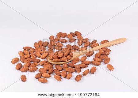 Delicious almond nuts in wooden spoon  and the basket on white background .