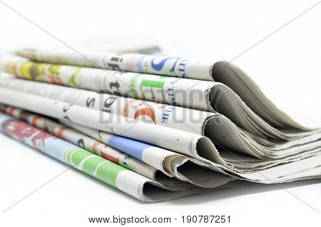 Newspapers folded and stacked isolated on white