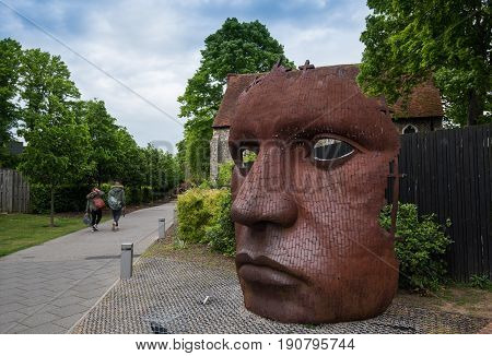 Canterbury Kent England - May 15 2017: The face Mask or Bulkhead art created by Rick Kirby British sculptor sitting outside Marlowe Theatre at the city of Canterbury Kent UK.