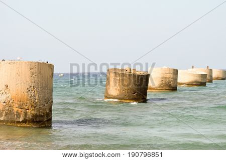 Several old concrete feet used as supports for a pipeline on the ocean of Crete