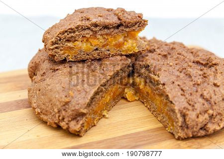 Cut apricot pie with slices on a cutting board