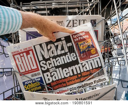 PARIS FRANCE - JUN 12 2017: Man point of view personal perspective buying at press kiosk German newspaper with reactions nazi schande am Ballermann