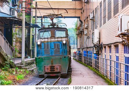 Electric narrow-gauge locomotive with the empty freight train moves through Yuejin town. Jiayang Mining Region. Sichuan province. China