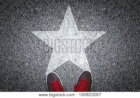Sneakers on asphalt road with white star