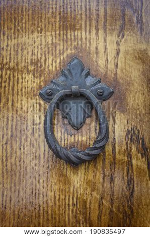Old wooden door detail. Iron knocker on old wooden door