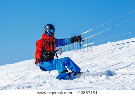 Snowboarder with a kite on fresh snow in the winter in the tundra of Russia against a clear blue sky. Teriberka Kola Peninsula Russia. Concept of winter sports snowkite.