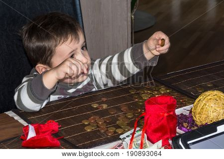 Child and a pile of money coins. Concept Save money.