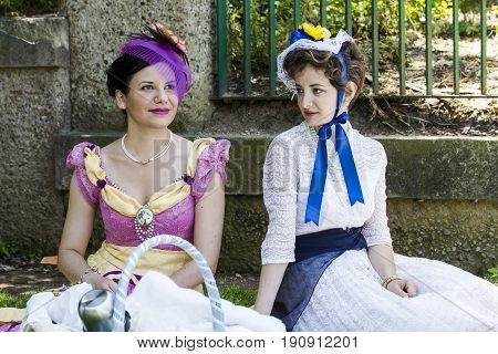CAGLIARI, ITALY - MAY 29, 2016: Sunday at the Great Jatte VIII Ed. At the Public Gardens, couple of beautiful women in Victorian costume - Sardinia