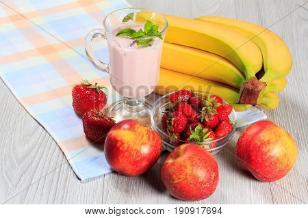 Glass Of Yogurt  With Mint And Fresh Strawberries, Nectarine, Banana On The Table