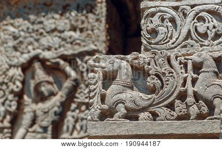 Background in Indian raditional style with reliefs and fantasy birds inside the 12th century Hoysaleshwara temple in Halebidu, Karnataka state, India