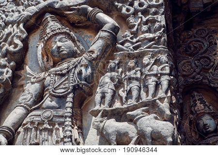 Fragments of monument with Lord Krishna lifting Mt. Govardhan. Old relief of the 12th century ornate Hoysaleshwara temple in Halebidu, India