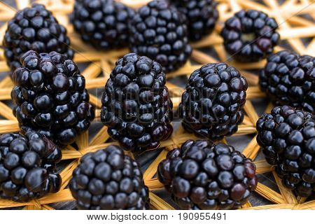 Ripe and fresh blackberries on a background of a straw mat.