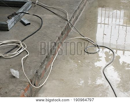 COLOR PHOTO OF WIRE ON WET CONCRETE GROUND