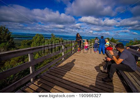 AUCKLAND, NEW ZEALAND- MAY 12, 2017: Unidentified people enjoying the beautiful view from top in the mountain in Rangitoto Island walking in wooden paths, New Zealand in a sunny day.