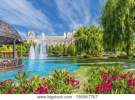 Water fountain in central square in Iasi town Cultural Palace in background Moldavia Romania.