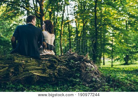 lovely cople sits in park on sunset