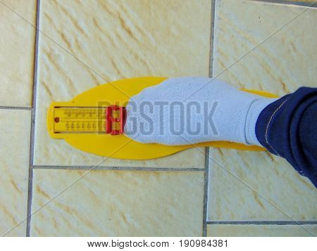 yellow foot measurement device with foot upon