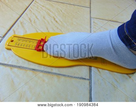 yellow foot measurement device with foot upon