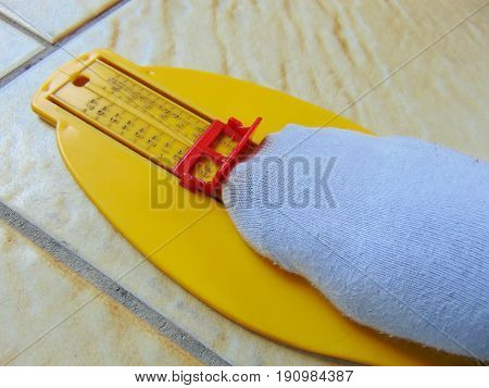 yellow foot measurement device with foot upon