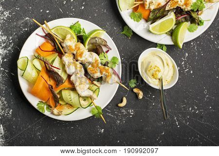 Cashew chicken skewer with peanut sauce and vegetables. Top view.