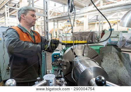 Turner Worker Manages The Metalworking Process Of Mechanical Cutting On A Lathe