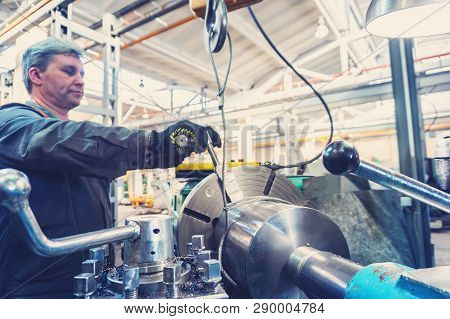 Turner Worker Manages The Metalworking Process Of Mechanical Cutting On A Lathe