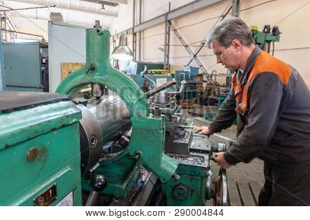 Turner Worker Manages The Metalworking Process Of Mechanical Cutting On A Lathe