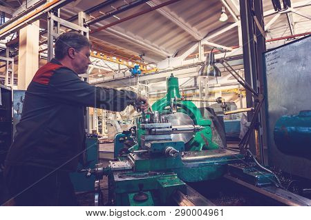 Turner Worker Manages The Metalworking Process Of Mechanical Cutting On A Lathe