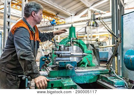 Turner Worker Manages The Metalworking Process Of Mechanical Cutting On A Lathe