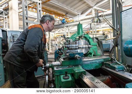 Turner Worker Manages The Metalworking Process Of Mechanical Cutting On A Lathe