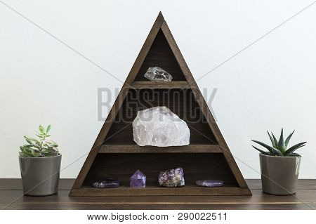 Triangular Wooden Crystal Shelf With Succulent Plants Either Side On A Wooden Surface