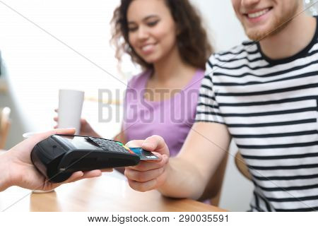 Clients Using Credit Card Machine For Non Cash Payment In Cafe, Closeup
