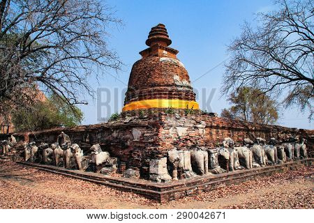 Ruined Buddhism Pagoda Surrounded By Broken Elephant Sculptures In An Old Wat (temple) In Ayutthaya,