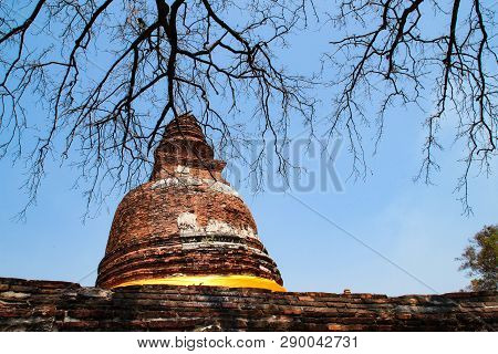 Partial View Of Ruined Pagoda In An Old Wat (temple) In Ayutthaya, Thailand With Glimpse Of Dried Tr