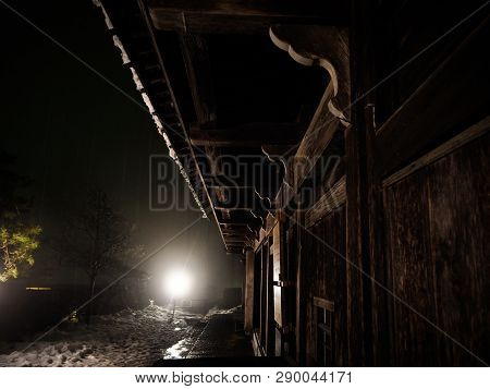 Snow Covered Entrance Area Of Old Japanese Wooden House At Night With One Source Of Lighting