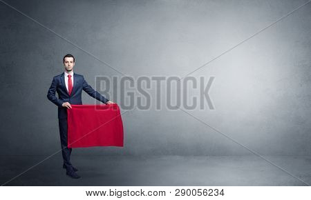 Businessman standing with red toreador cloth in his hand in an empty room